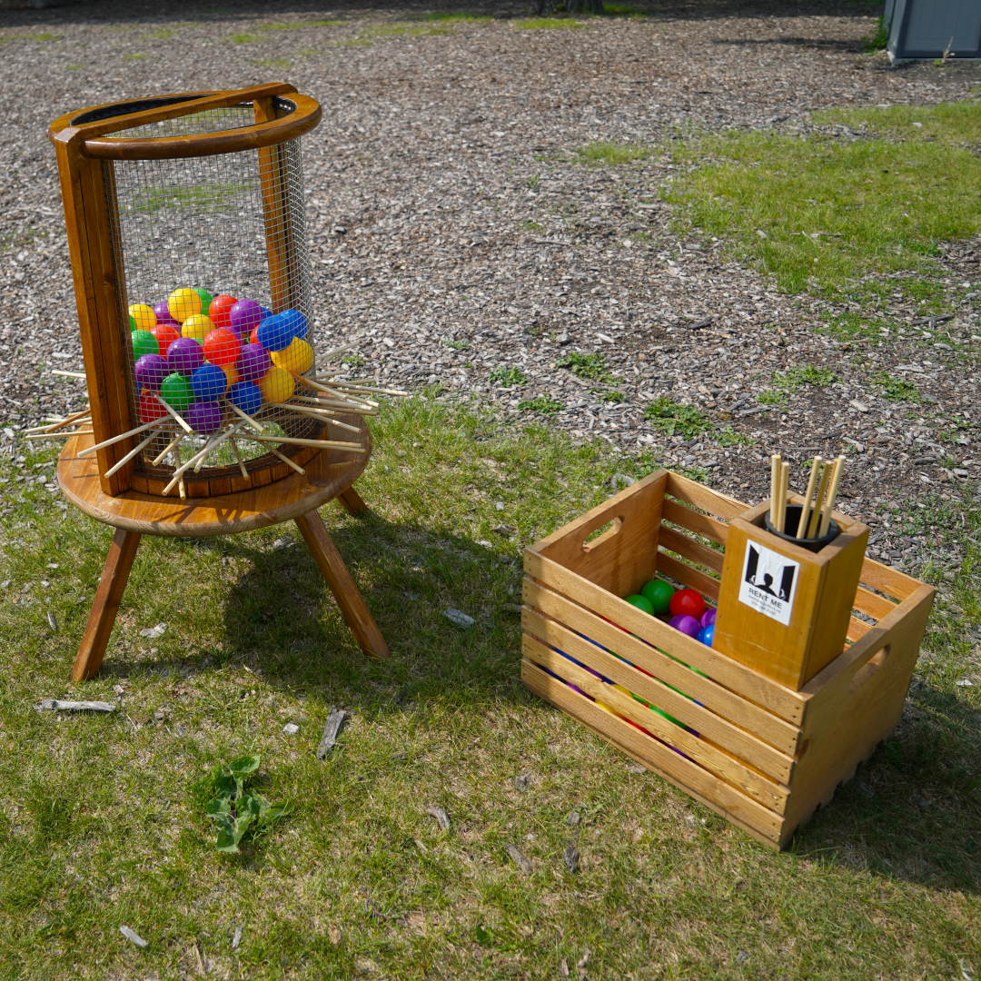 a game with sticks at the bottom and colourful balls inside