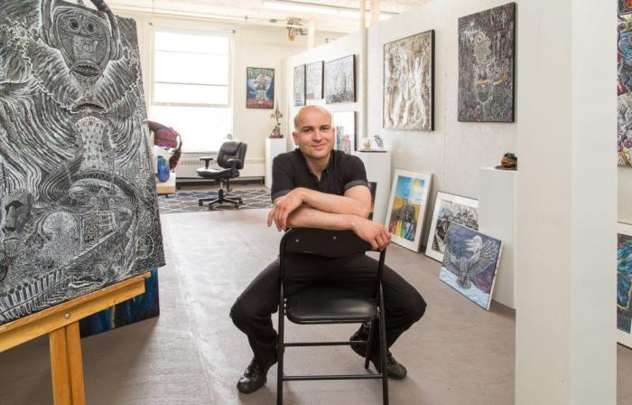 ryan smoluk seated on a chair in his studio