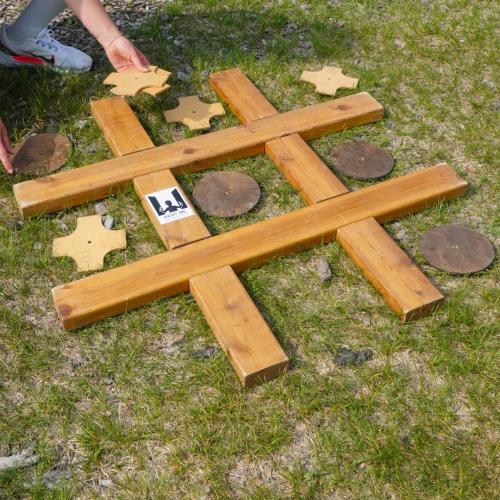 a giant wooden game of tic tac toe on grass